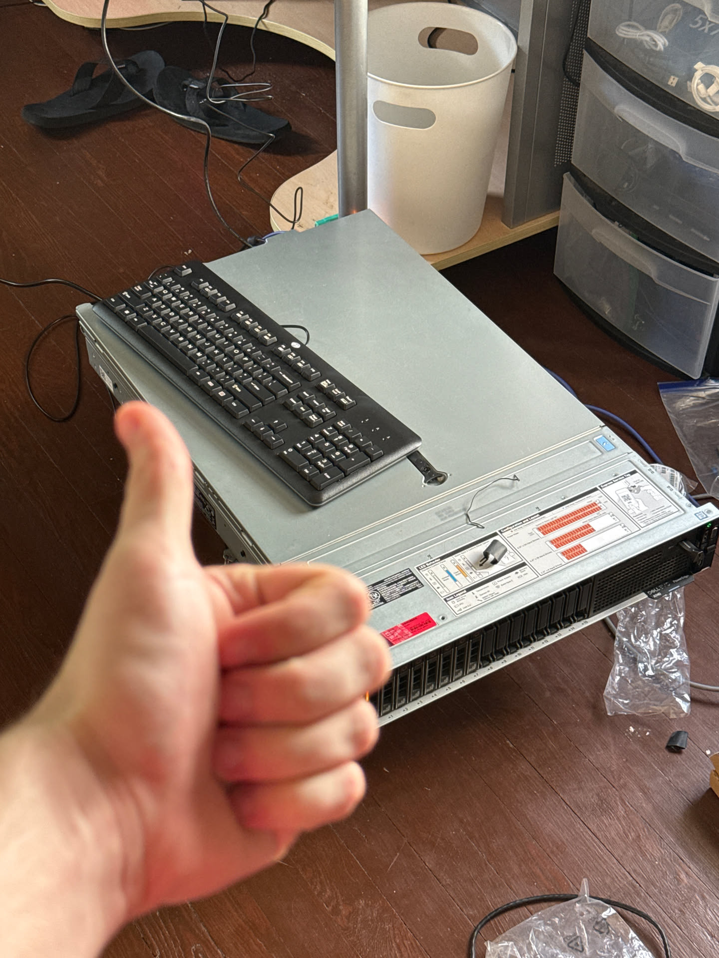 A Dell PowerEdge R740 sitting on a hard wood floor with a thumbs up from behind the camera